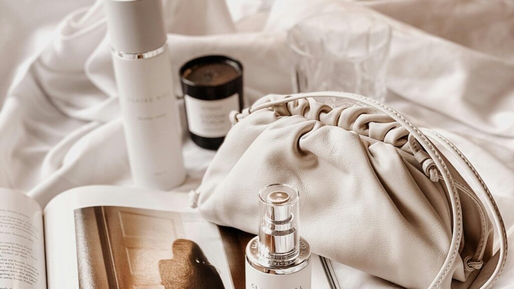 Soft-lit vanity scene with skincare bottles, open magazine, and natural morning light — evoking the best glow primers that last all day