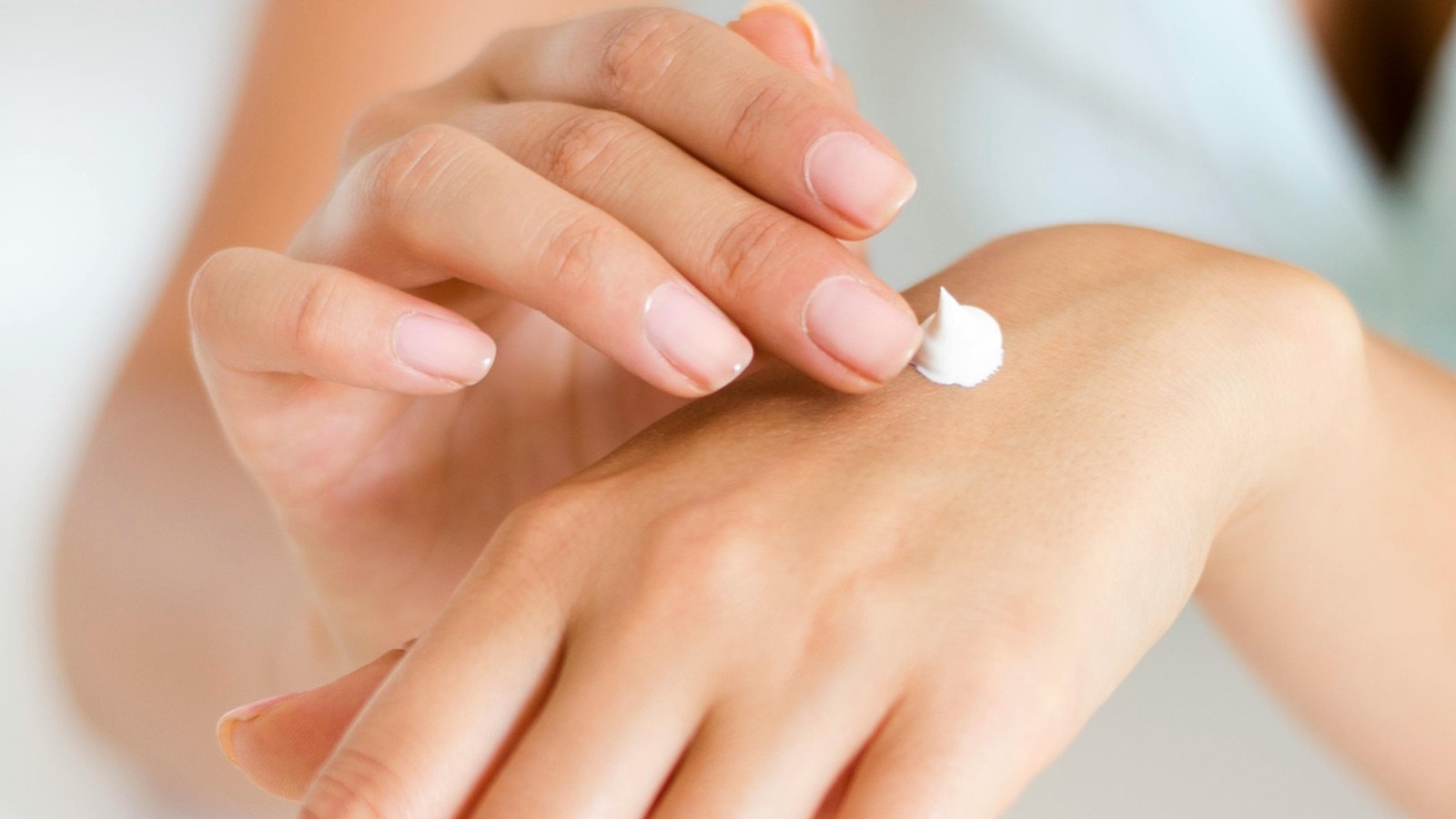 Hands applying cream with a visible dab, illustrating makeup that feels like skincare