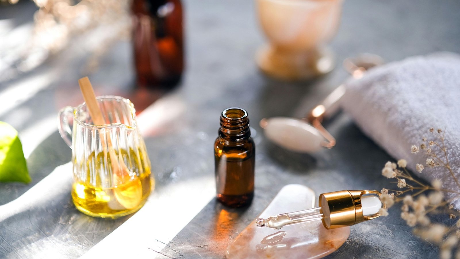 Skincare products for glowing skin arranged on a marble surface in morning light