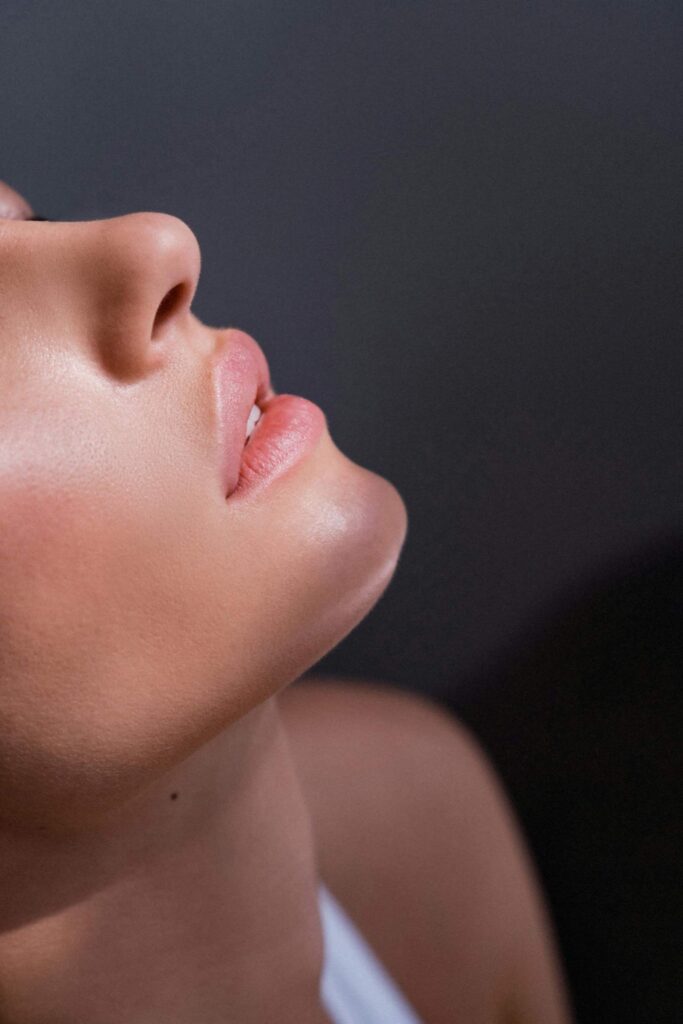 Close-up of glowing skin and lips in soft light, representing skincare routines