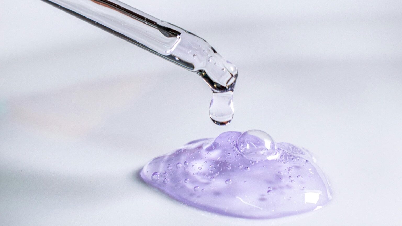 Clear dropper dispensing a lilac gel texture — a visual cue for must-have hydrators that layer like a dream.