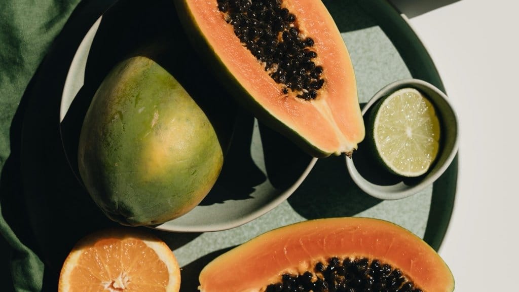 Sliced papaya and citrus fruits on plate — best exfoliants for glowing skin