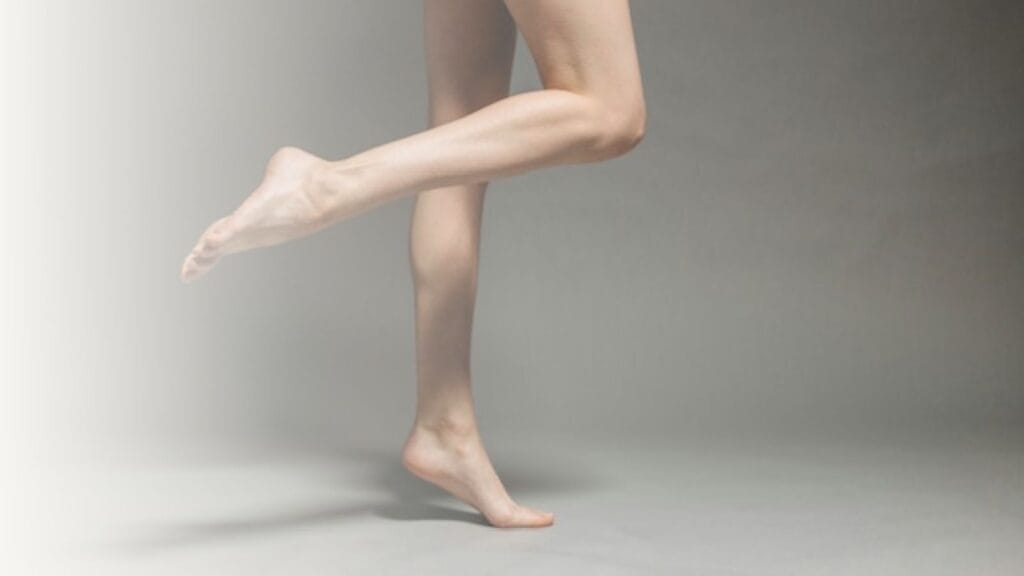 Bare legs against grey background.