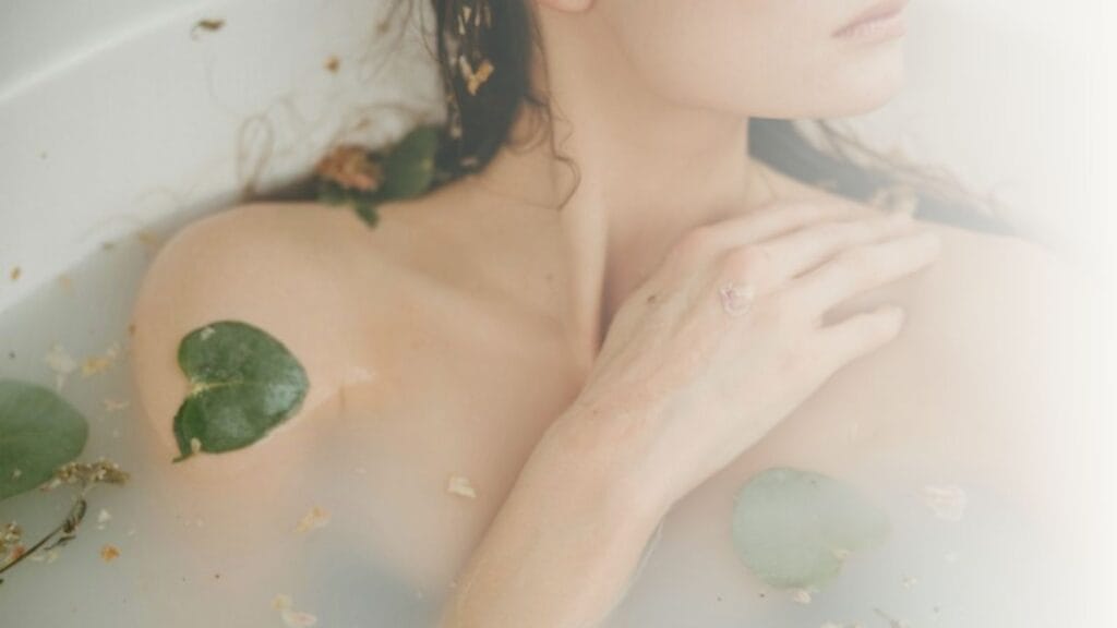 woman in bathtub with green leaves