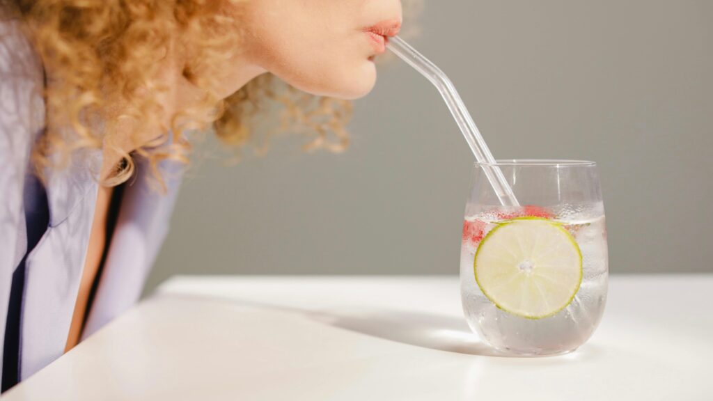 Woman drinking water representing skin barrier repair routine.