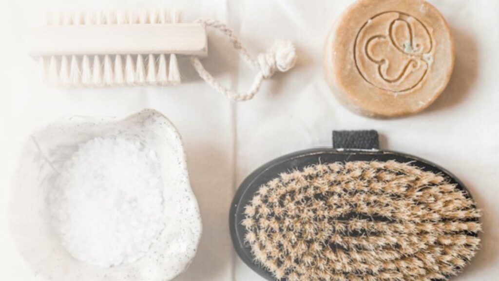 Exfoliating tools including salt, body brush, soap.