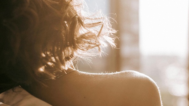 Woman's bare shoulder against sunshine in background.
