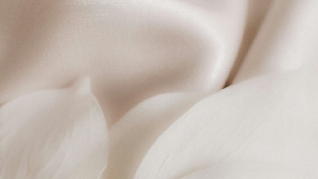 A silky cream smudge alongside white flower petals representing most luxe night creams.
