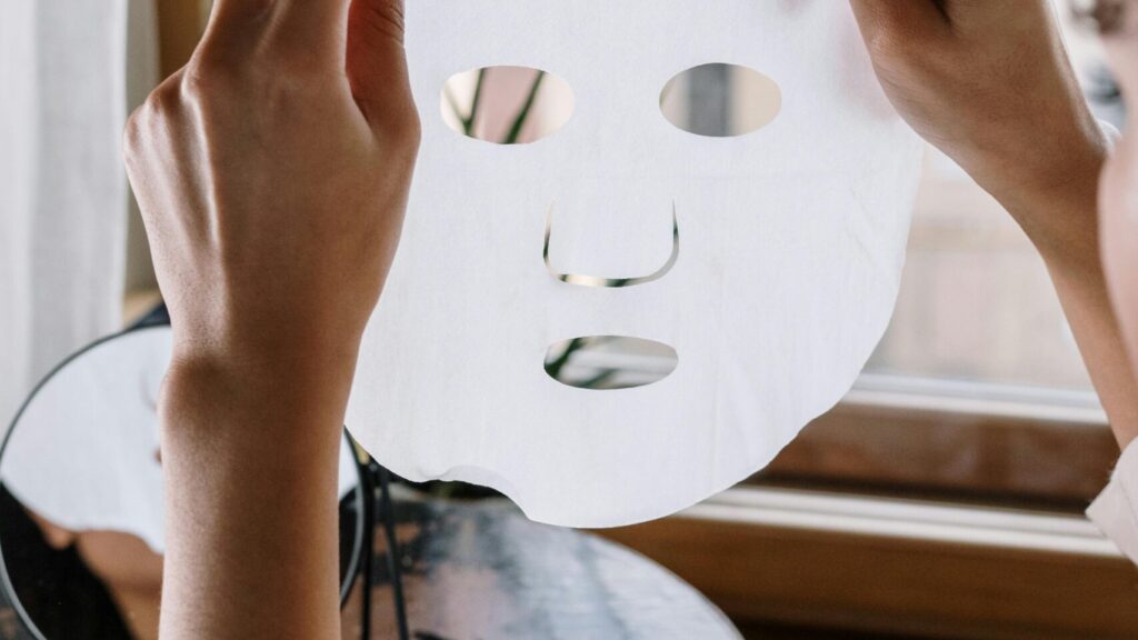 A sheet mask held against the light showcasing best overnight masks for glowing skin.