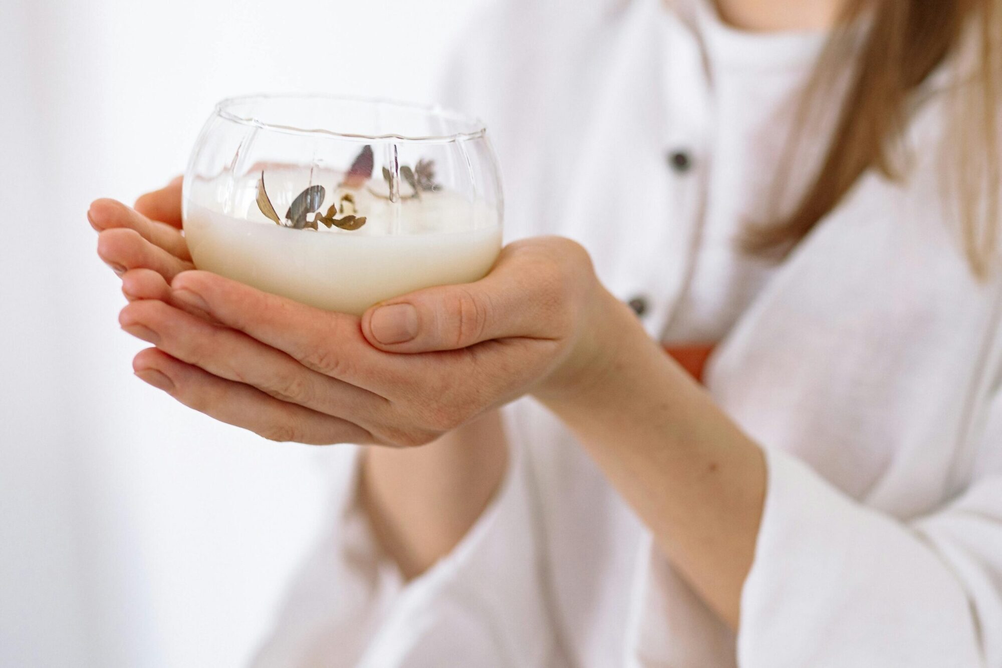 Woman holding candle representing 5PM reset for stress and skin.