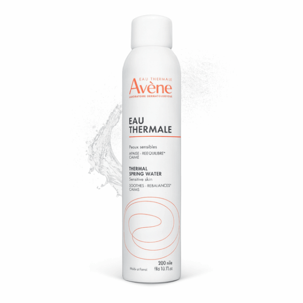 Avene Eau Thermale Mist bottle in white with water splatter behind on white background.