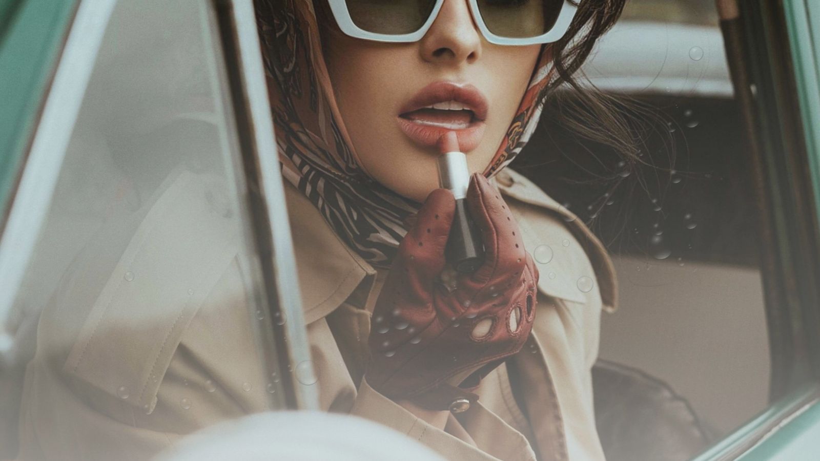 Woman putting lipstick on in the car — showcasing best multi-use makeup products for glow on-the go.