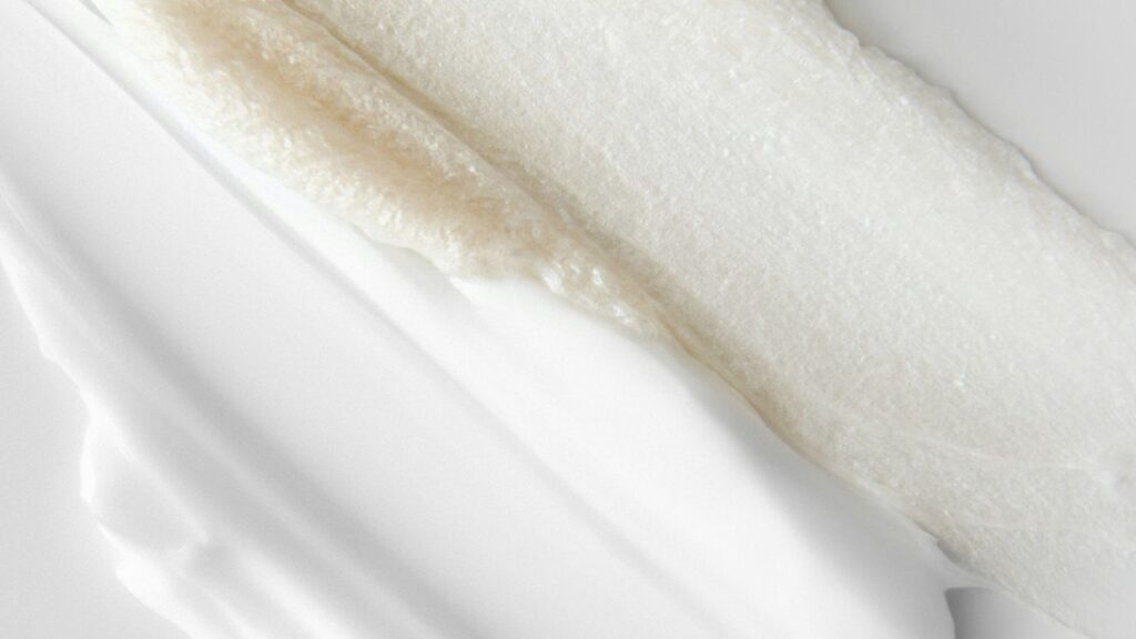 Moisturizer and creamy cleanser smears side by side — essential skincare products for glowing skin.