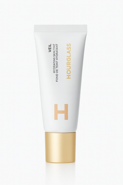 Veil hydrating skin tint in a white tube and gold top.