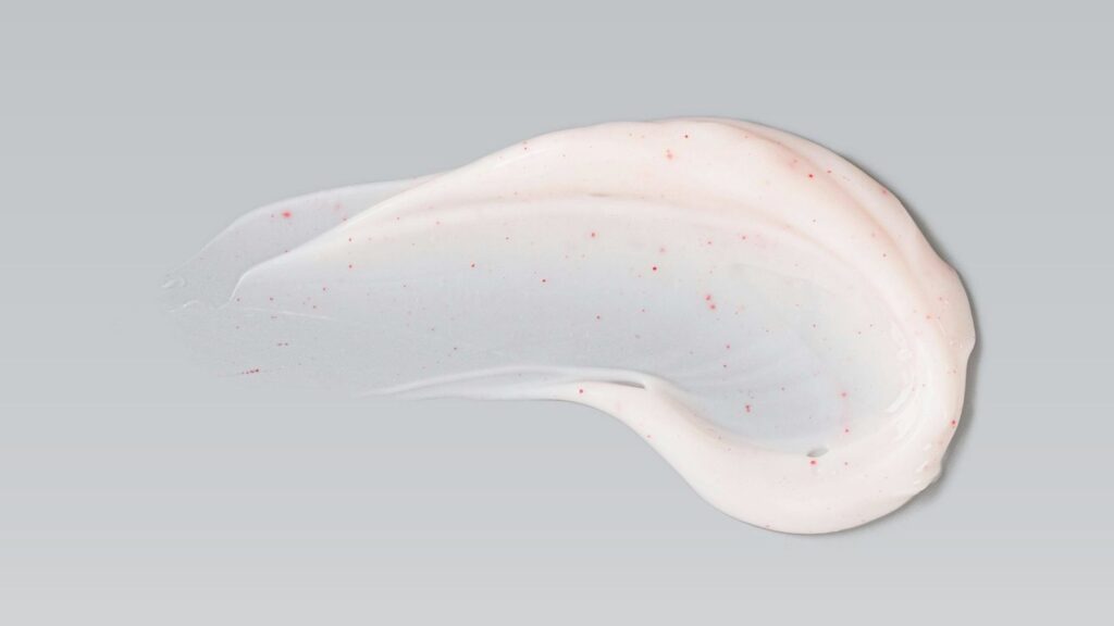 Exfoliator smear on grey background — representing best exfoliators for glowing skin in winter.