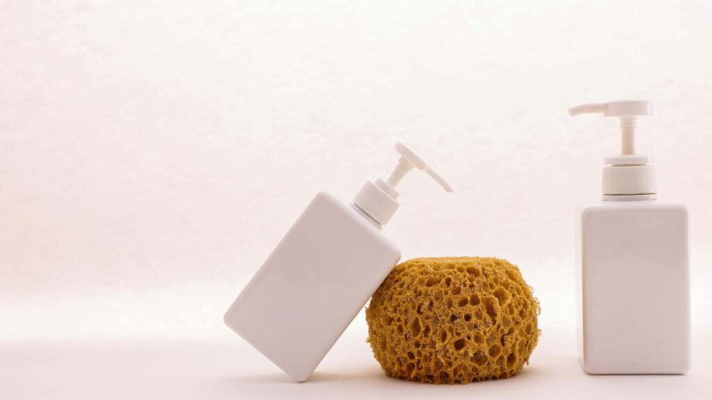 Gentle exfoliation for dry skin represented by loofah and lotion bottle.