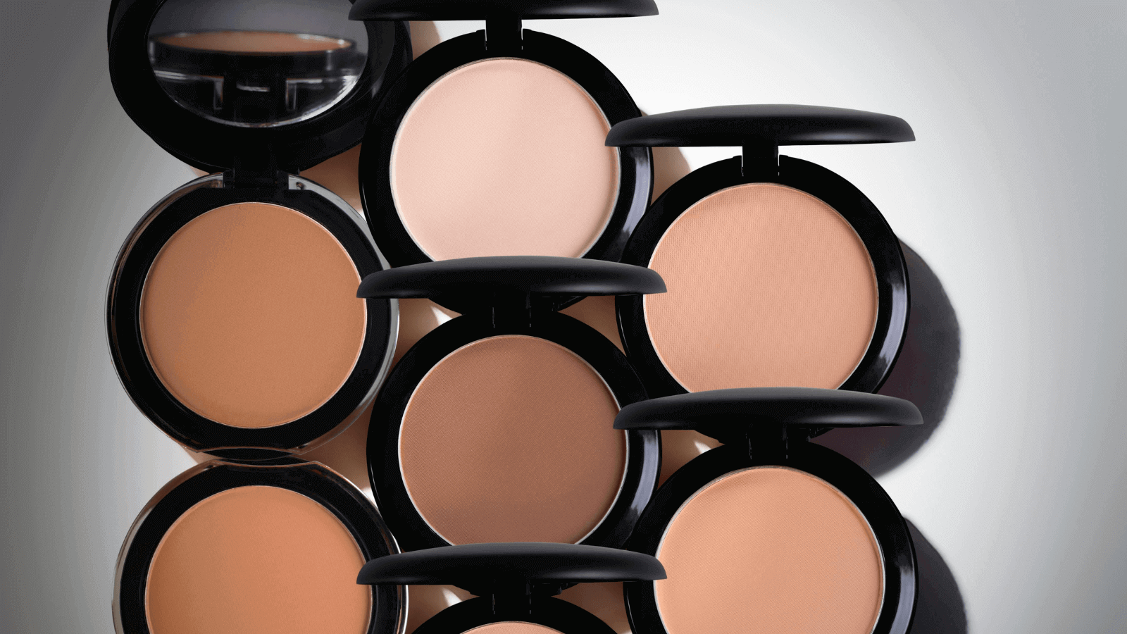 Best Foundations for Every Skin Type represented by multiple stacked foundation compacts.
