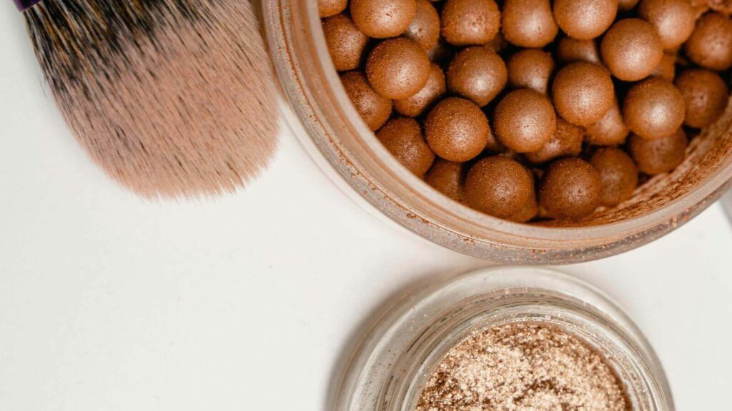 Cream bronzers that blend without disturbing your base showcased by bronze pearls.