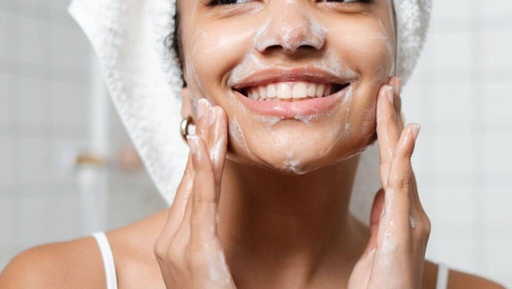 Morning skincare routine for glowing skin illustrated by smiling woman gently foaming face.